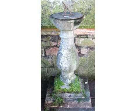 A reclaimed two sectional sundial with square stepped platform base supporting a baluster pedestal, with circular dial and pi