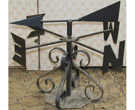 A small iron work weather vane with arrow shaped pointer, scrolled supports and octagonal platform base, 30 cm high x 43 cm i