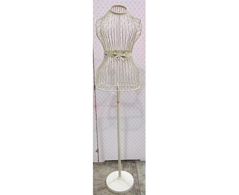 A contemporary cream painted light steel mannequin, female torso, raised on a tubular stand with disc shaped platform base 