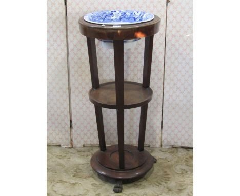 A 19th century mahogany washstand on three circular tiers, the upper with cut out bowl receptacle containing a removable Spod