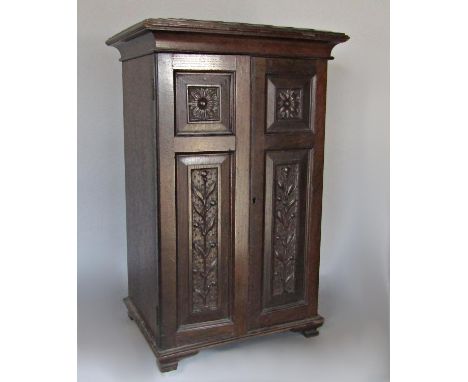 Collectors cabinet in bog oak with eight mahogany drawers, with fish scale detail to the top and floral carved panelled doors