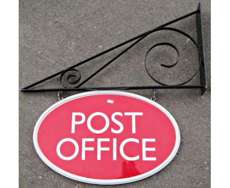 An oval wooden painted double sided exterior post office sign and wall mounted angular bracket with simple scrolled detail 