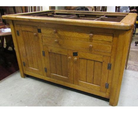 A good quality bespoke oak freestanding kitchen island enclosed by an arrangement of cupboards and drawers beneath a vacant m