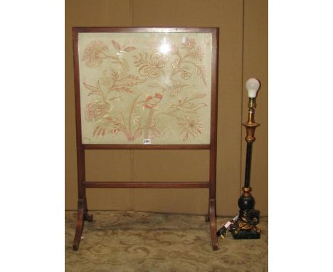 An Edwardian mahogany firescreen with hand worked material panel representing a Jacobean style floral frieze, together with a