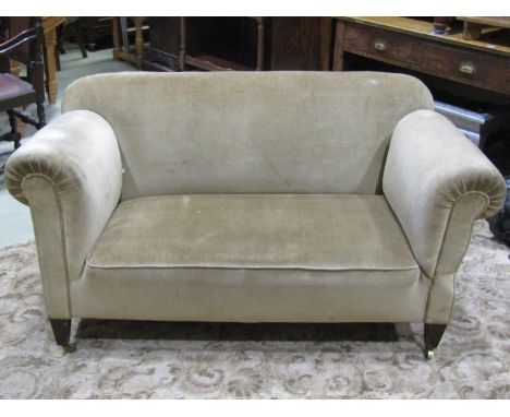 An Edwardian two seat single drop end sofa with traditional rolled arms and upholstered finish raised on square tapered forel