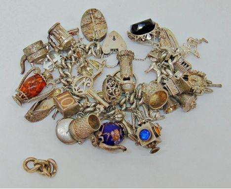 Good silver curb link charm bracelet with heart padlock clasp, hung with a collection of novelty charms to include ice skate,