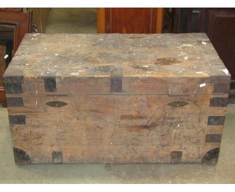 A 19th century pine trunk with hinged lid, strap reinforced corner fittings, two locks, drop side carrying handles, 100 cm lo