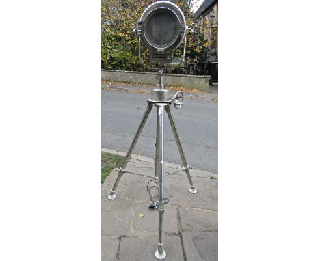 A large vintage style electric floorstanding drum shaped theatre light raised on a folding and height adjustable tubular trip