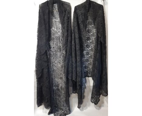 Two 19th century Victorian black lace shawls; the first is a curved shape with a floral design and scalloped edge, probably o