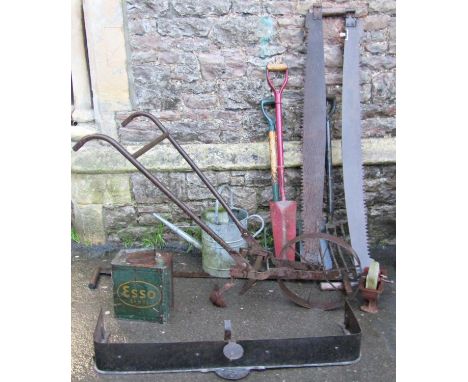 A vintage single wheeled push hoe, galvanised watering can, two two-man cross cut saws, four long handled gardening tools, sm