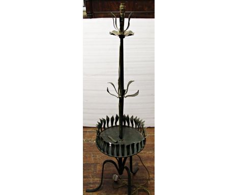 A decorative ironwork lamp standard, raised on a tripod base, with central tray and stylised leaf moulded detail 