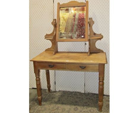 A late Victorian/Edwardian stripped pine dressing table, the raised central swing mirror with rectangular bevelled edge plate