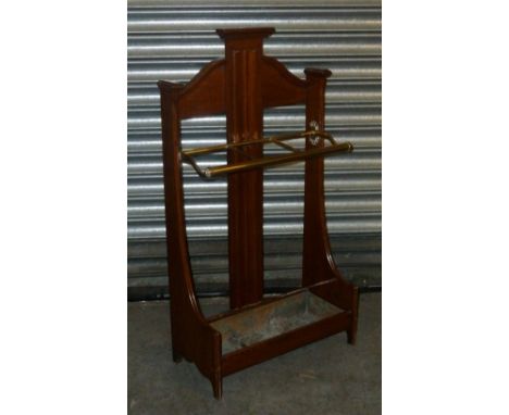 A VICTORIAN MAHOGANY STICK STAND, THE SHAPED BACK WITH BRASS FRAME, INSET TIN TRAY, LINEN FOLD DECORATION TO THE BACK SPLAT 