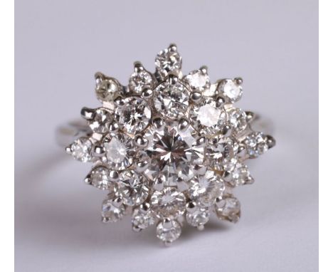 A 18ct white gold diamond cluster ring. Approx UK size K. 5.2g. Approx 1.6carats of diamonds with a central stone being appro