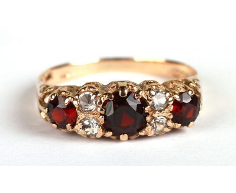 A 9ct gold ring set with three garnets and four diamonds, approx UK size 'Q', 2.3g.