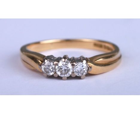 An 18ct gold three-stone diamond ring, approx UK size 'N', 3.7g.