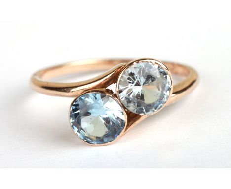 A 9ct gold two-stone crossover ring set with pale blue stones, approx UK size 'K', 2.2g.