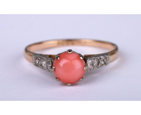 An 18ct gold ring set with a coral cabochon and diamond set shoulders, approx UK size 'M', 2g.