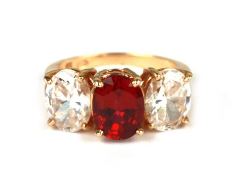 A 14ct gold three-stone dress ring with a large oval red stone flanked by two white stones, approx UK size 'L', 4.8g.