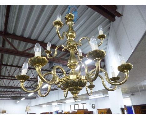 A LARGE HEAVY TWELVE BRANCH TWO TIER BRASS CHANDELIER, and eight brass door knobs (9)