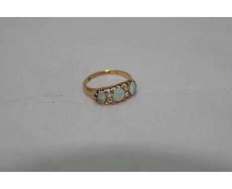 A HALLMARKED 18CT YELLOW GOLD BOAT RING, having central oval opal flanked by two diamonds and two further opals either side, 