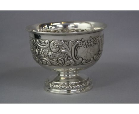 A SILVER FOOTED BOWL, having floral and scroll embossed decoration, cartouche inscribed 'K' London 1899, approximately 11cm d