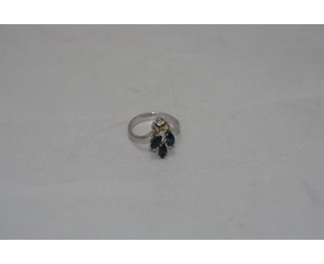 A LADIES DRESS RING, having three oval blue stones over three clear stones to white metal wishbone band, ring size K