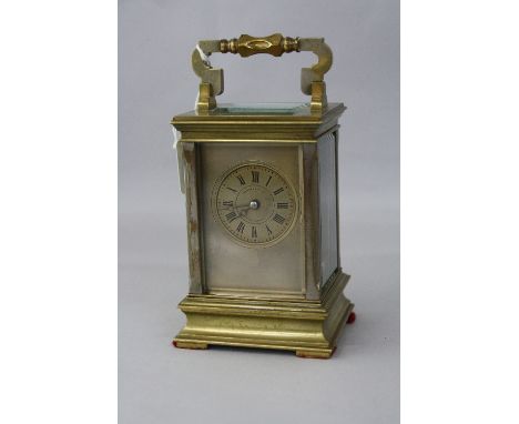 A BRASS CASED CARRIAGE CLOCK, having Roman numeral dial inscribed Howell & James London & Paris, bevelled glass, carrying han
