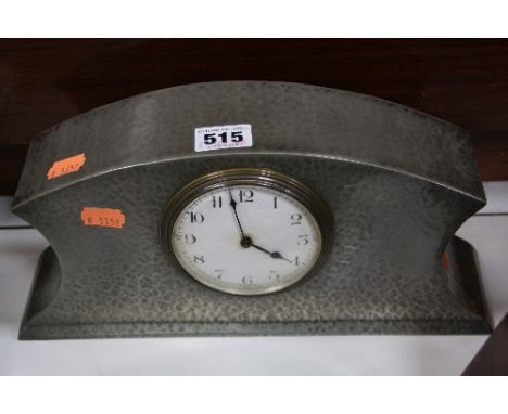 A BEATEN PEWTER BARREL MANTEL CLOCK, having Arabic numeral dial, approximately 29cm x 7cm x 14.5cm high