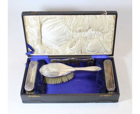 A George V lady's silver clad dressing table set, comprising hairbrush, two clothes brushes, and a comb, in fitted leather ca