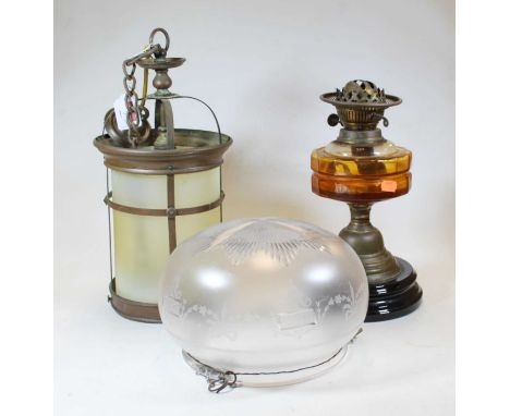 An early 20th century brass oil lamp, with amber tinted glass font, h.31cm; together with a 20th century copper hanging lante