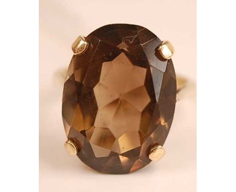 A modern 9ct gold and smoky quartz set dress ring, the four claw set oval cut quartz measuring approx 21x15x8mm, 6.6g, size O