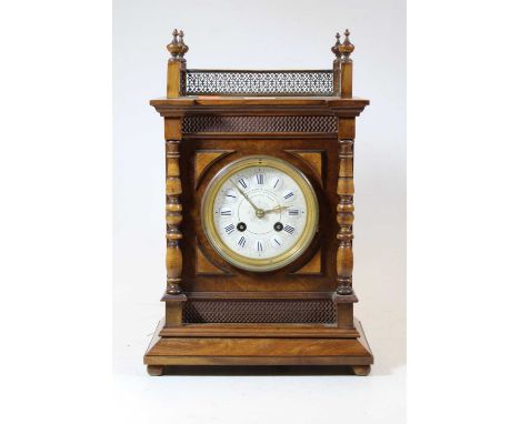 A late 19th / early 20th century walnut cased mantel clock, having eight-day movement, the dial with enamelled Roman numeral 