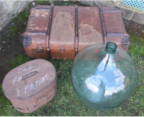 A glass carboy, trunk and hat box