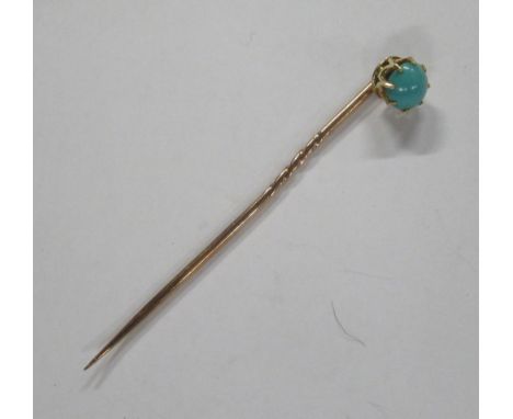 A gold stick pin, set with a turquoise