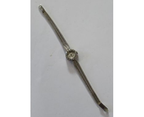 An 18K Ebel white gold lady's diamond set cocktail watch, the circular dial with baton numerals, the bezel set with sixteen r