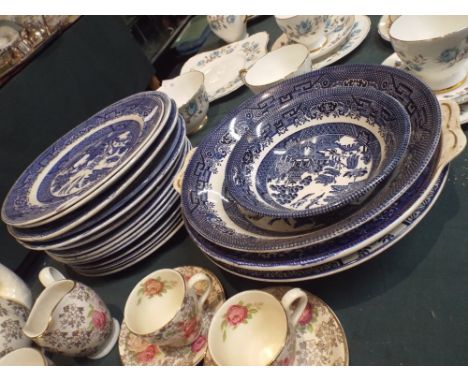 A Collection of Blue and White Willow Pattern Plates and Bowls