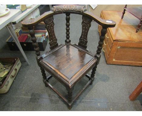 A 19th Century carved oak corner chair with stretcher base, bobbin legs and supports, foliate carved detail to arm rests and 