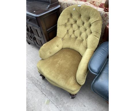 A VICTORIAN BUTTON-BACK FIRESIDE CHAIR ON TURNED FRONT LEGS WITH PORCELAIN CASTERS 