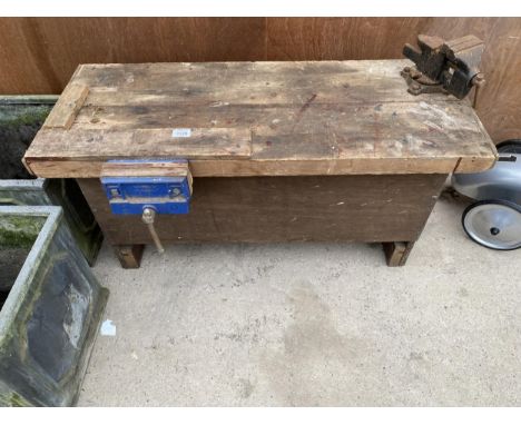 A VINTAGE WOODEN TOOL STORAGE CHEST COMPLETE WITH TWO VICES AND AN ASSORTMENT OF TOOLS TO INCLUDE SAWS ETC 