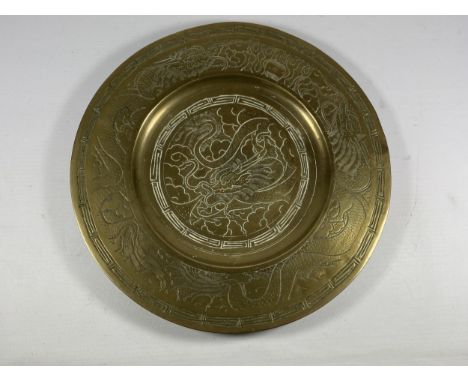 A CHINESE BRASS CHARGER WITH DRAGON DESIGN, SEAL MARK TO REVERSE, DIAMETER 24CM 