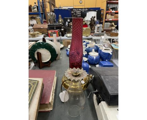 A BRASS OIL LAMP COVERTED TO ELECTRIC WITH TWO FUNNELS ONE CRANBERRY GLASS AND THE OTHER  CLEAR GLASS 