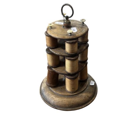 A 19th century wooden milliners cotton reel stand, with twelve reels (one empty) 28cm high
