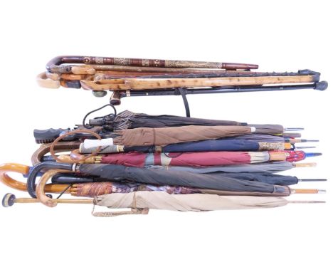 The ex contents of an umbrella stick stand, featuring several walking of varying woods and styles and an assortment of modern