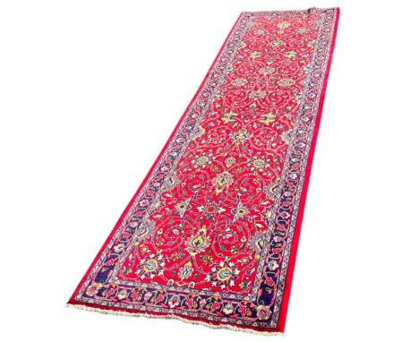 A Northwest Persian Sarouk runner, with a repeating floral pattern 300cm x 80cm