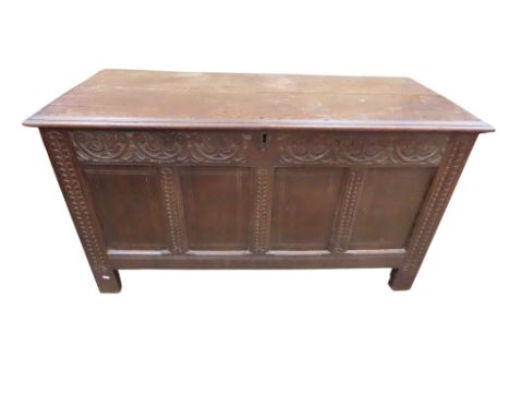 An 18th century oak coffer, the four panel front with repeating carved detail, 75cm high x 140cm x 63cm
