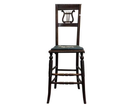 A regency beechwood child's correction chair with lyre shaped splat and cane seat on swept supports 