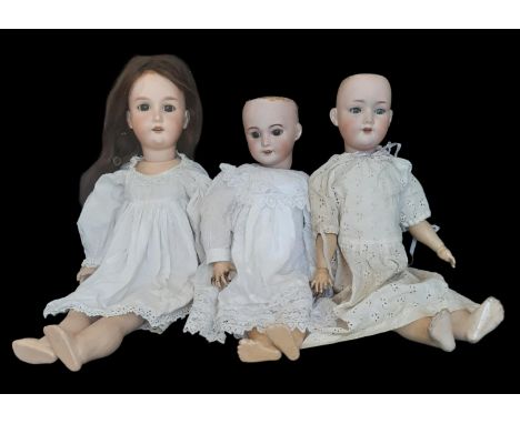 Three early 20th century bisque head dolls comprising a SFBJ Company doll mould 301 with brown closing eyes and pierced ears,