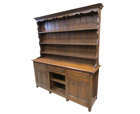 A 19th century Welsh oak dresser, with associated and closed Delft rack over three drawers above a pair of panelled cupboard 