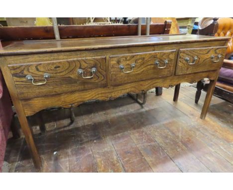 A Georgian style cottage dresser base in elm, enclosing three drawers and shaped frieze, 76cm high x 155cm x 45cm